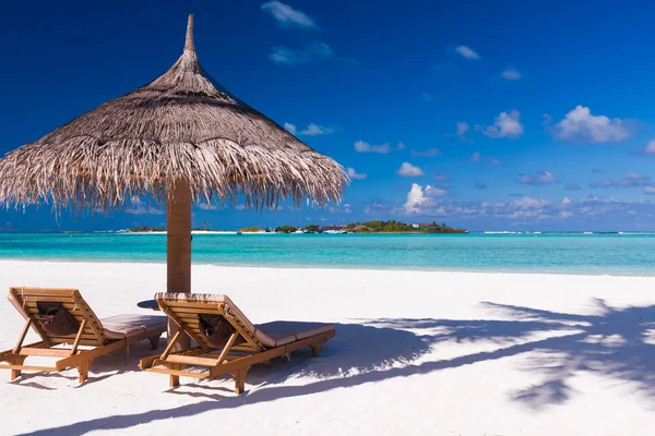 Стулья и зонтик на пляже с тенью от пальмы Лицензионные Стоковые Изображения