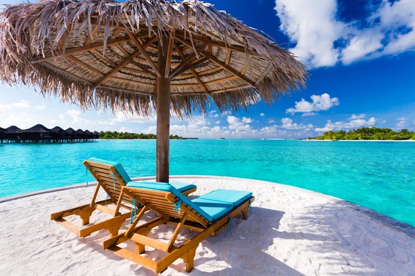 Два стула и зонтик на тропическом пляже Лицензионные Стоковые Фото