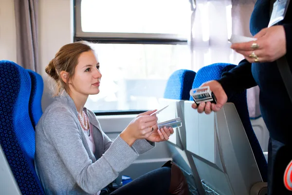 Женщина с ее билет проверен проводник поезда Стоковое Изображение