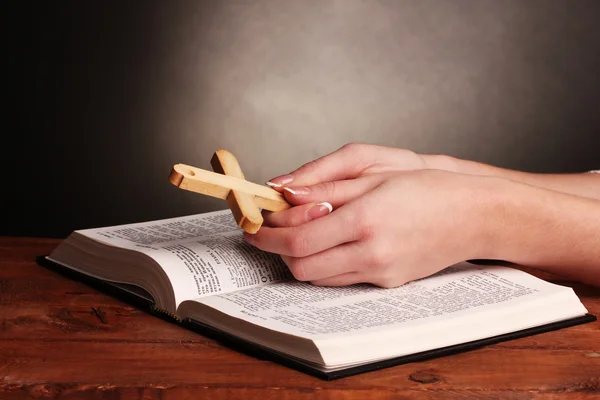 Руки сложенными в молитве на открытие русской Библии — стоковое фото