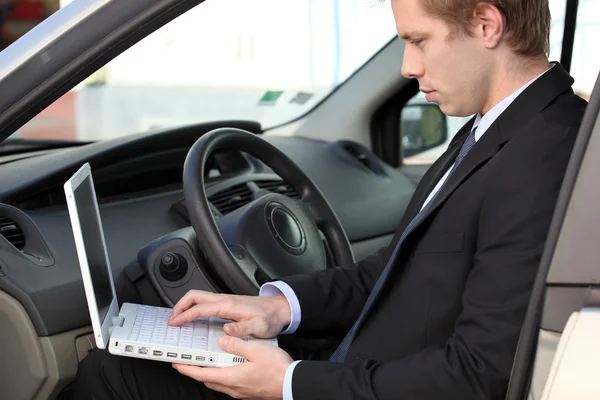 Бизнесмен, используя ноутбук в своем автомобиле — стоковое фото