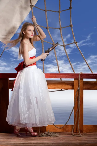 Красивая девушка в белом платье на палубе парусного корабля — стоковое фото
