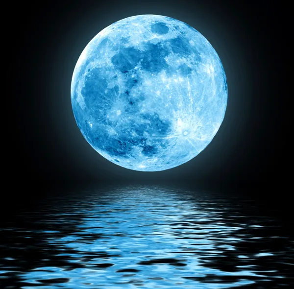 Полная Голубая Луна над водой с отражениями Лицензионные Стоковые Изображения