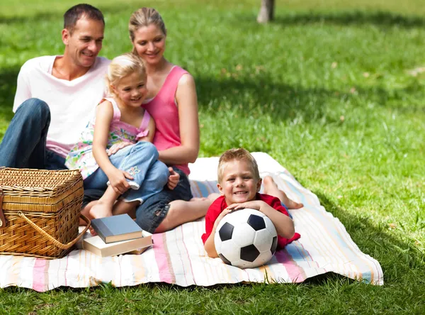 Счастливые родители и дети picnicing в парке — стоковое фото