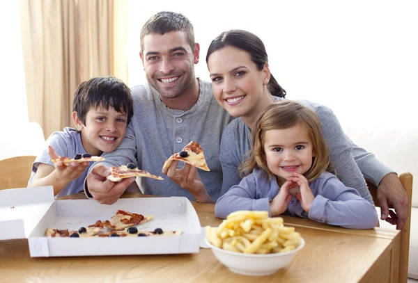 Родители и дети едят пиццу и картофель на дому — стоковое фото