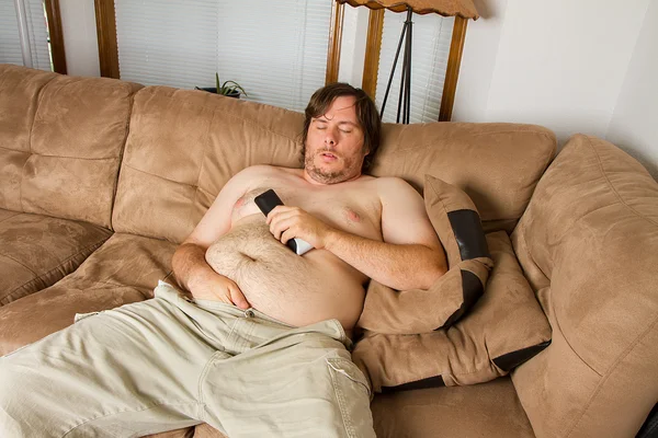 Толстый парень спит на диване — стоковое фото