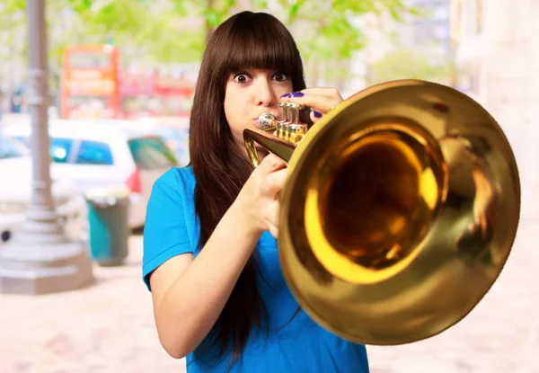 Портрет молодой девушки, дует труба — стоковое фото