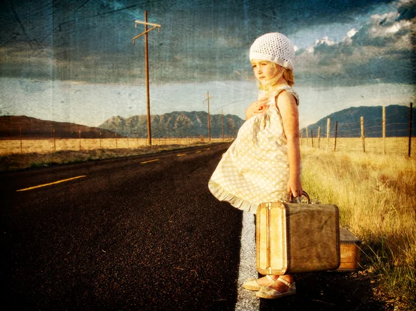 Молодая девушка на стороне дороги с чемоданами — стоковое фото