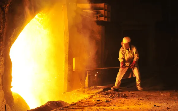 Работник берет образец в сталелитейной компании — стоковое фото