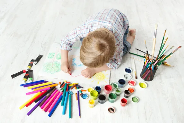 Рисования рисунок ребенка с карандаш в альбом, используя много краски — стоковое фото