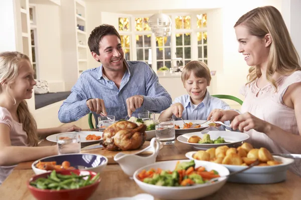 Счастливая семья, обедающая за столом Стоковое Изображение