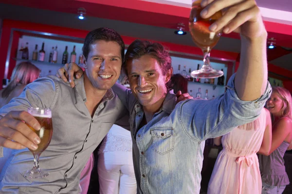 Двое молодых людей, с удовольствием в оживленном баре — стоковое фото